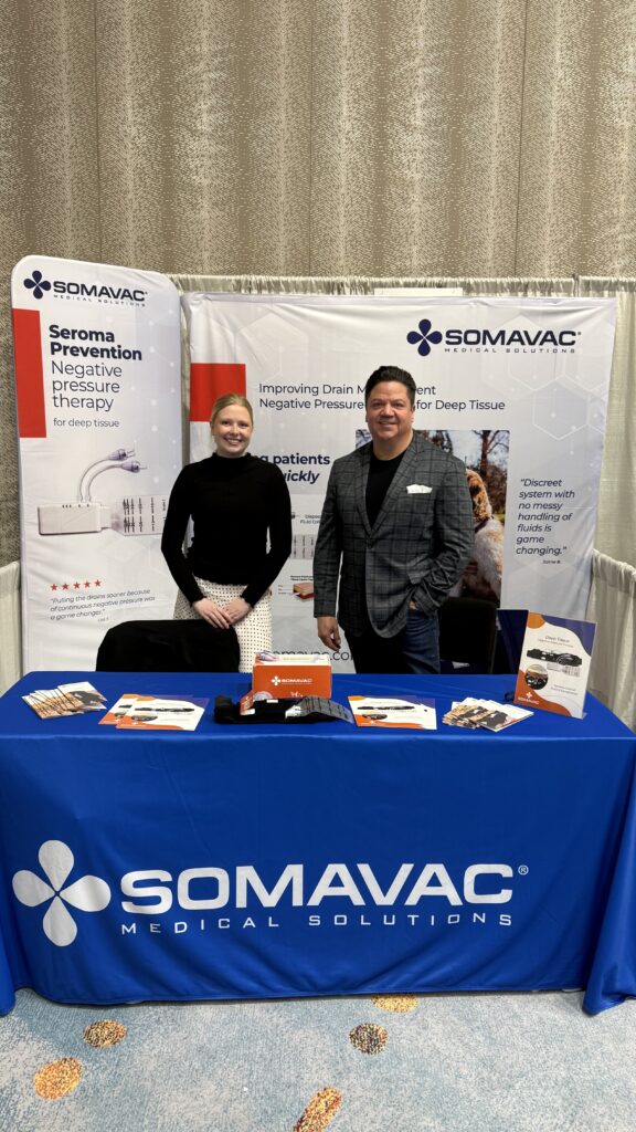 Somavac booth with representatives and promotional materials.